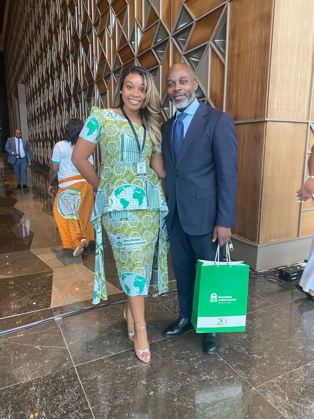 Two attendees pose in the lobby; one is wearing BANGE's commemorative fabric print.